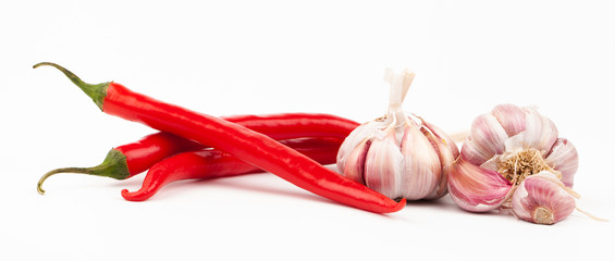 Red chilli peppers and garlic cloves on white background