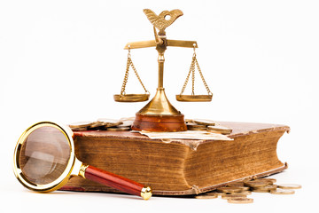 law book, money , magnifying glass and scales of justice