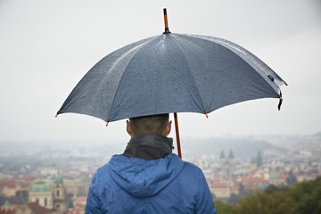 Rainy day in Prague - young man with umbrella