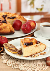 slice of tasty homemade pie with jam and apples and cup of