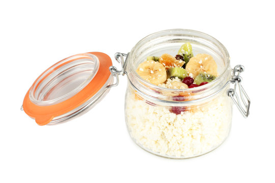 Cottage cheese in glass bottle with exotic fruits, isolated