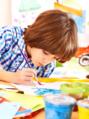 Child painting at easel.