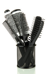 Iron basket with combs and round hair brushes, isolated on