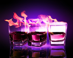 Three glasses of burning purple absinthe