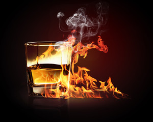 Glass of burning yellow absinthe
