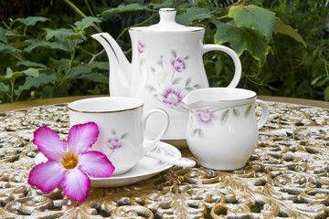 Tea Time in the Garden with Desert Rose Flower on Golden Table