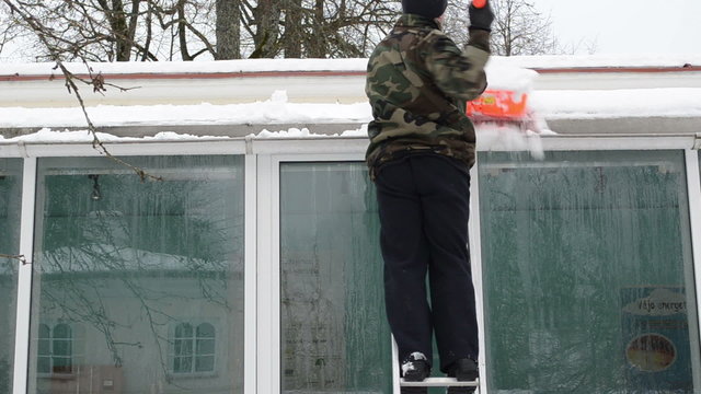 man camouflage ladder orange shovel tool clean snow roof winter
