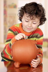 Fototapeta premium Little boy with his a big piggybank
