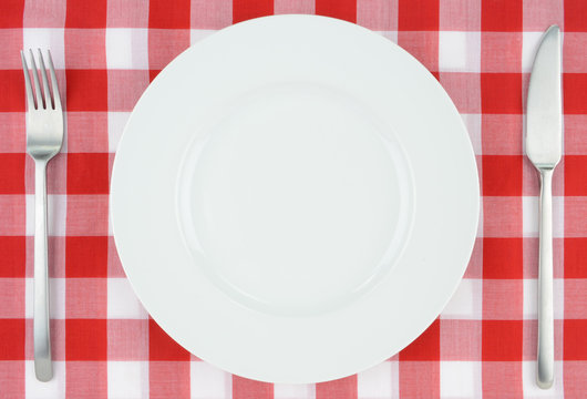 White plate on red and white checkered cloth