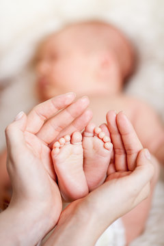 mother hands holding small baby's feet