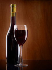 Red wine glass and Bottle on a wooden background