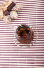 A cup of tea with a plate with cookies