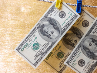 dollar bills hanging on a clothes pins