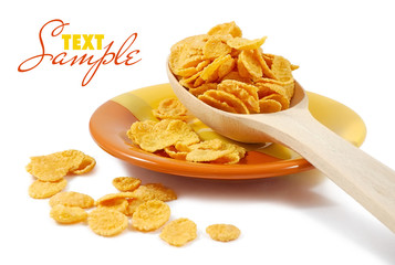Corn flakes and wooden spoon on a dish isolated on white
