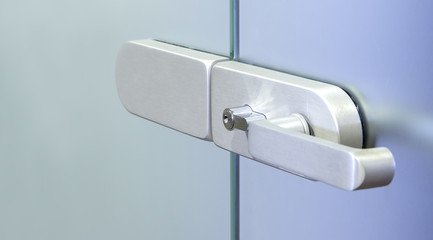 Modern metal office door handle on a glass door