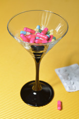 Cocktailglas mit Pillen