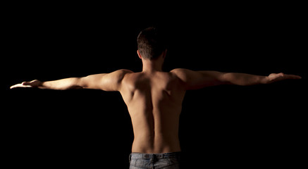 Fototapeta na wymiar Shirtless young man with arms outstretched