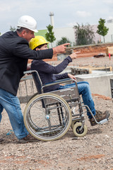 Obraz premium Architect shows disabled woman in wheelchair construction sites
