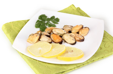 Snack of mussels and lemon on plate isolated on white