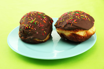 Tasty donuts on color plate on color background
