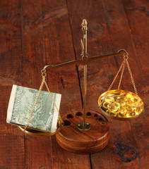 Classic scales with color pills on wooden background