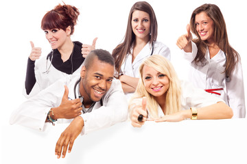 Young medical students smiling making positive thumb gesture