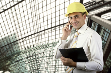 Fototapeta premium Young architect wearing a protective helmet standing on the buil