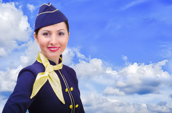 Beautiful young  smiling stewardess on a background sky