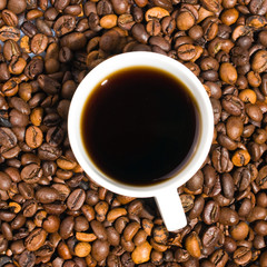 A cup of coffee with coffee bean as background