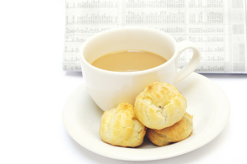 a cup of coffee and eclairs against newspaper
