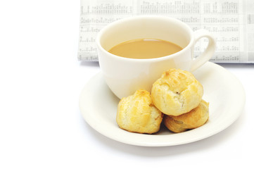 a cup of coffee and eclairs against newspaper