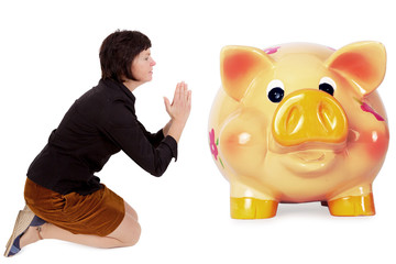 Kneeling woman praying in front of the piggy bank