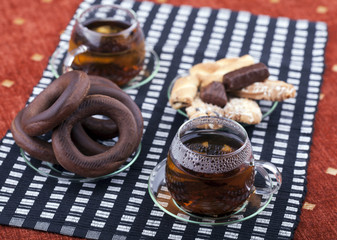 Two cups of tea with two plates with cookies