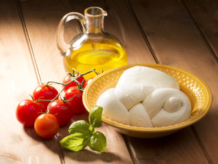 mozzarella cheese with olive oil and tomatoes on wooden table