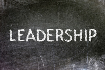 Leadership handwritten with white chalk on a blackboard.