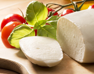 mozzarella cheese with olive oil and tomatoes on wooden table