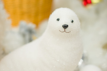 Toy seal in front of decorated christmas tree with toys and ligh