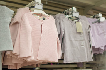 Kids sweaters on stands in supermarket