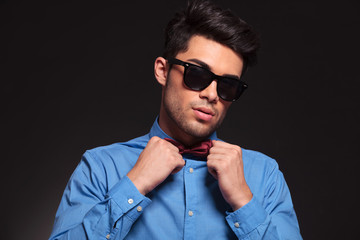 Obraz premium young fashion man holding his bow tie