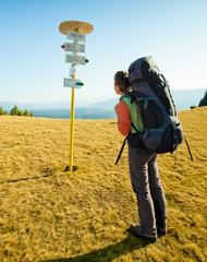 Hiker women is looking at arrow signs