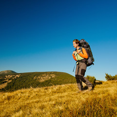 Hiker walking in autumn mountains