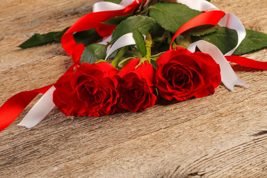 Red roses on wooden background