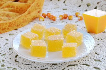 Homemade tangerine jellies on crocheted tablecloth