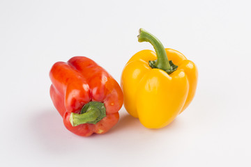 Red and yellow sweet pepper on white background