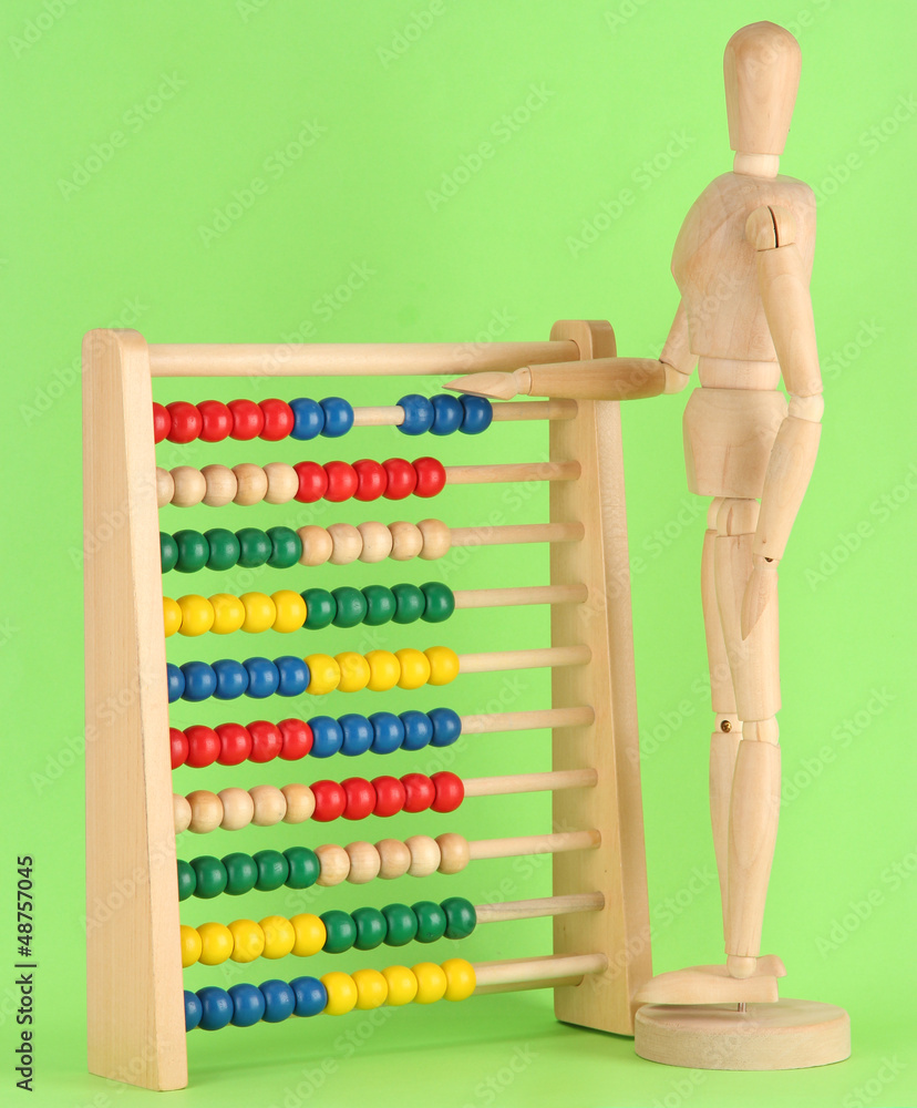 Wall mural bright toy abacus and wooden dummy, on green background