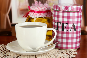 Jar and cup of tea on table in room