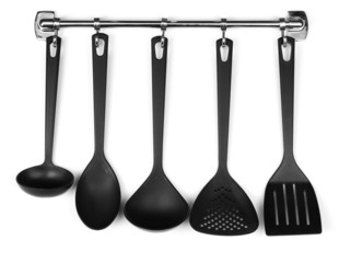 Black kitchen utensils on silver hooks, isolated on white