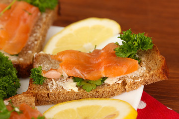Salmon sandwich on plate,on wooden background, close up
