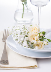 table setting with roses in bright colors and vintage crockery