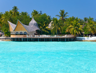 Maldives. A sandy beach, houses and an ocean coast
